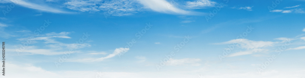 Obraz premium Soft clouds drift gently across a vast, serene blue sky