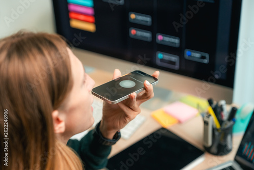 Bilde på lerret Modern woman using voice commands on her smartphone to interact with AI assistan