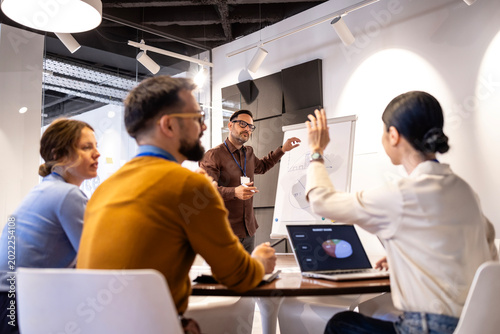 Foto Business professionals discussing market data during an internal presentation, t