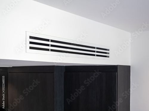 Obraz na plátně Air conditioning vent on wall ceiling in hotel room interior, featuring ventilation system, cooling airflow, and minimal design for comfort living, HVAC technology, and indoor climate control concept