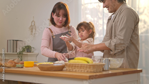 Schilderij op canvas The parents are helping their daughter knead dough to make bread
