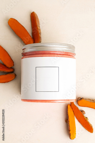 beauty products for skin care, bright bottles of orange cream, turmeric flavor on the beige background