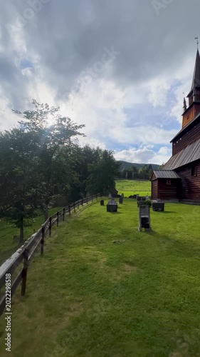 12th-century wooden viking church in Kaupanger in western Norway, surrounded by lush greenery in a natural environment, with no people in view. Nordic history