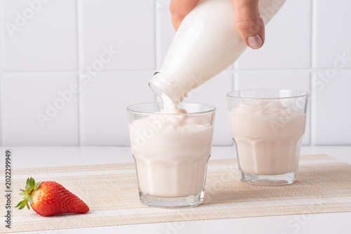 Photos Pouring homemade kefir, buttermilk or yogurt with probiotics