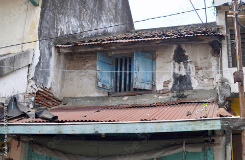 фотографія Weathered and dilapidated humble street building