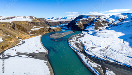 Aerial View of Turquoise River in Snowy Mountain Valley