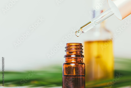 Photos Essential oil being carefully dispensed into an amber glass vial