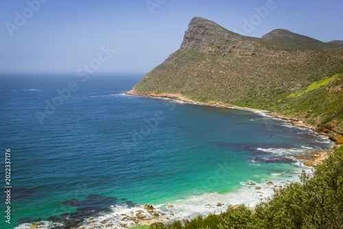 Dramatic cliff coastline with turquoise ocean bay and rocky shoreline at Cape Point, Cape Peninsula, Western Cape, South Africa