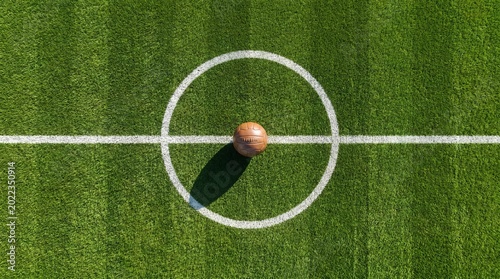 Vintage leather soccer ball placed in the center circle of a green grass football field