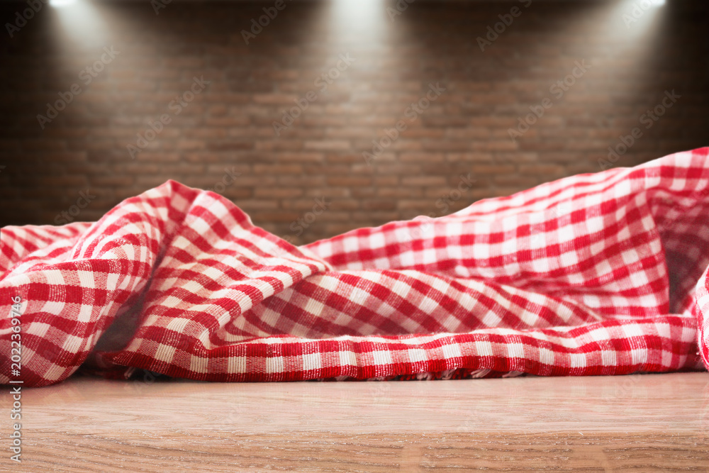 Obraz premium Checkered Picnic Fabric Isolated on Brick wall with spot lights Background