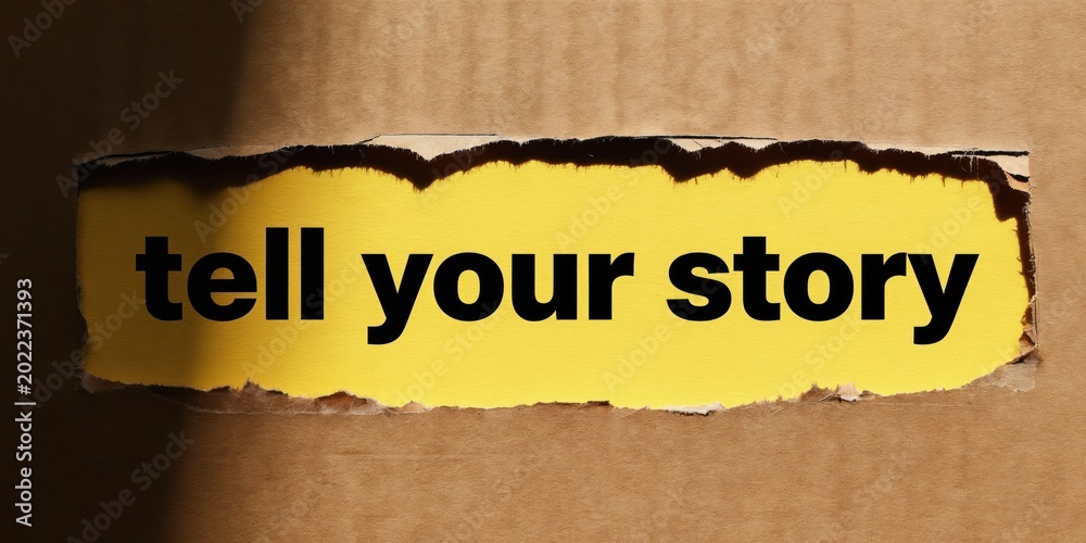 Naklejka premium Text saying tell your story appears on torn yellow paper. Concept for sharing personal tales and business promotion. Focus on communication and connection.