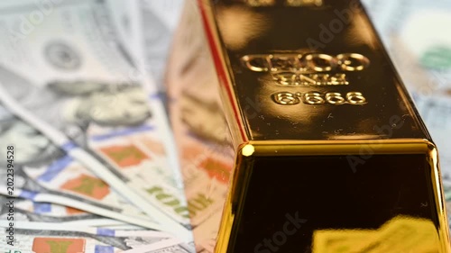 gold bars with dollar bills
