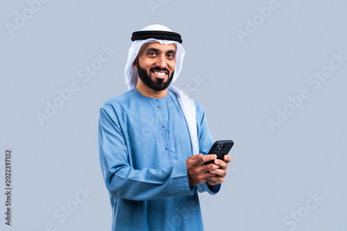 Middle eastern man smiling using smartphone technology