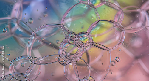 Soap bubbles display iridescent reflections and delicate structural patterns in a macro close-up composition.