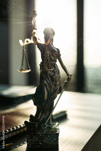 Obraz na plátne Close up of Lady Justice statue holding scales and sword on desk, symbolizing divorce law, legal dispute, custody battle