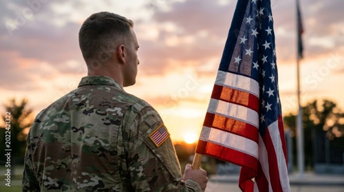 Man in army uniform holding american flag at sunset in cemetery. Patriotic tribute to u.s. armed forces and military service