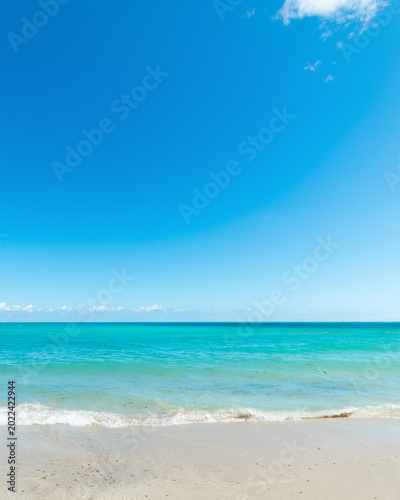 Tropical beach background with turquoise water white sand and blue sky in South Beach Miami