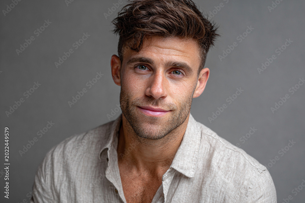 Fototapeta premium Professional headshot of a charming 23-year-old man with tousled hair and a friendly smile