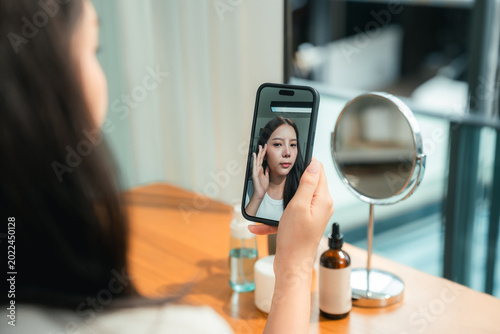 Fotografia Modern woman uses an AI skin analysis app at home, scanning her skin for instant