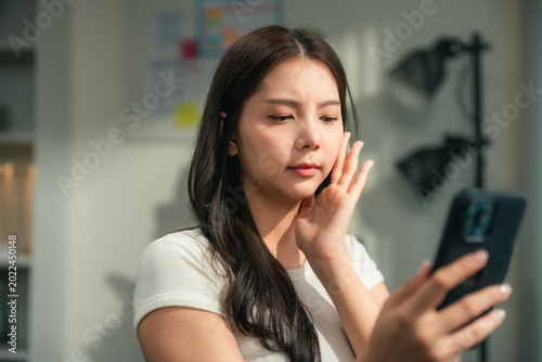 Bild auf Leinwand Modern woman uses an AI skin analysis app at home, scanning her skin for instant