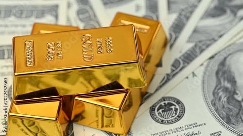 gold bars with dollar bills