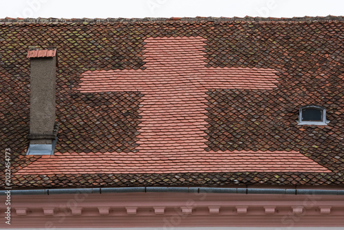 A Cross Beautifully Created from Tiles on the Roof of a Romanian Church in Transylvania