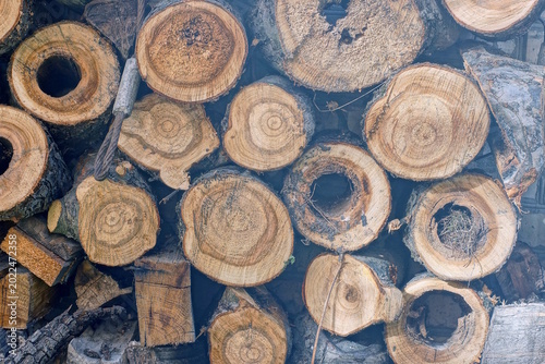 brown wood texture from heap of pine firewood against the wall in the street