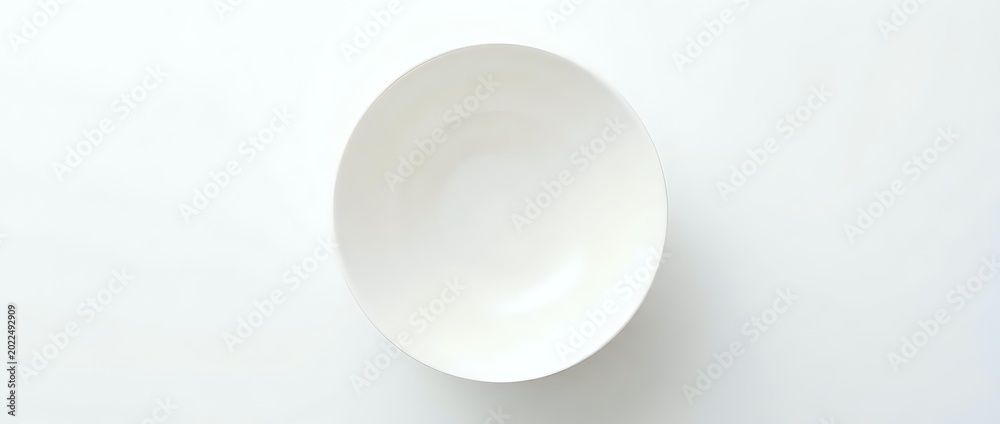 Fototapeta premium Empty white ceramic bowl shot from above on a white background, isolated and ready for design use in food, kitchen, and lifestyle projects.