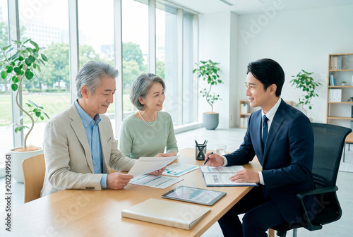 オフィスで営業マンと話すシニア夫婦
