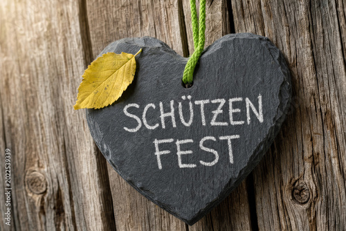 Slate heart-shaped sign with Schützenfest text hung on wood