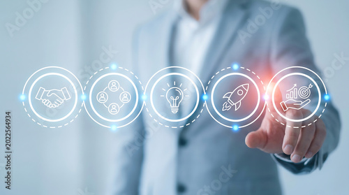Businessman interacting with digital interface showing business growth icons for startup success and corporate strategy development