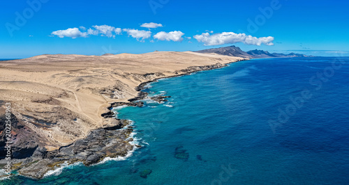 Tableau sur toile Aerial of Playa de Agua Liques Turquoise Coastline and Saharan Desert Dunes, Fue