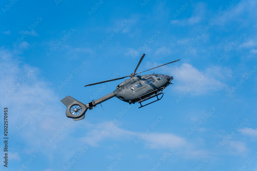 Fototapeta premium Modern military transport helicopter flying in the blue sky in Hungary