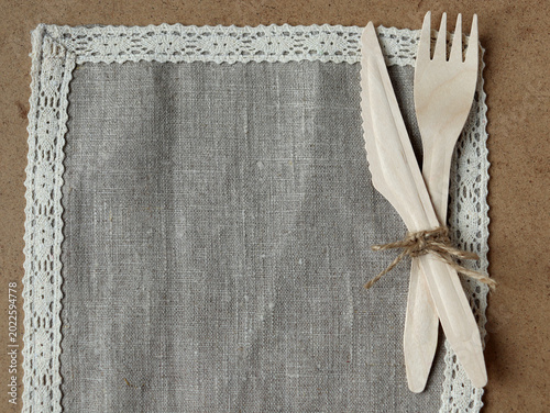 Foto Wooden cutlery placed on a gray cloth napkin with lace trim at a dining table se