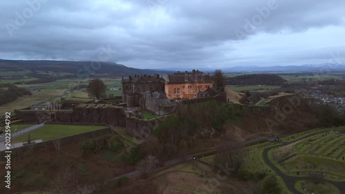 Stirling Scotland city skyline drone flyover and mountains in the distance. Clouds cover the sky, creating an atmosphere in the Scottish highlands