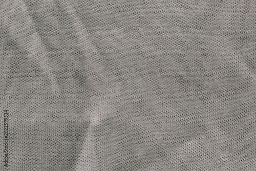 Seamless grey micro mesh fabric texture with soft shadows and weave.