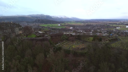 Stirling Scotland city skyline drone flyover and mountains in the distance. Clouds cover the sky, creating an atmosphere in the Scottish highlands
