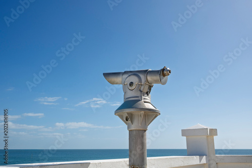 Slika na platnu Coin operated telescope on a seaside pier with blue sky and sea