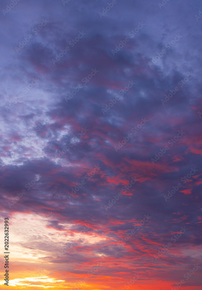 Fototapeta premium Dramatic vibrant sunset sky with purple and orange clouds,Beautiful dramatic sunset sky filled with vivid purple, blue, and fiery orange clouds, perfect for nature backgrounds, concepts of hope,
