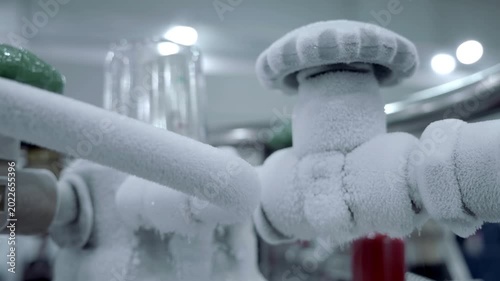 When the laser machine is actively working, a large amount of nitrogen is required and frost forms on the pipes and taps and evaporates, forming steam. Closeup. Shot in motion