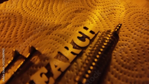 A coiled spring and screws are arranged near the word SEARCH on a textured surface.