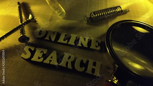 Shadows play across wooden letters spelling ONLINE SEARCH with various hardware components.