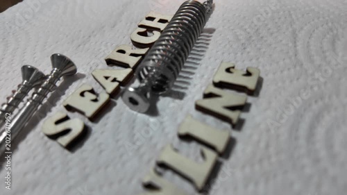 Wooden letters forming ONLINE and SEARCH are placed on a white paper towel background.