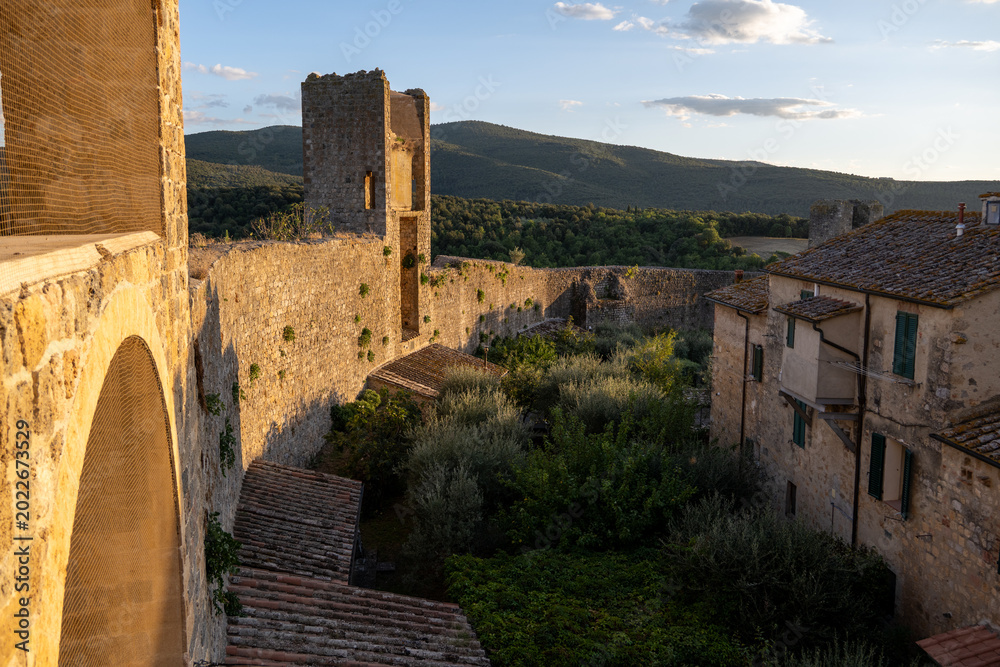 Fototapeta premium Golden hour rooftops and castle walls in Monteriggioni