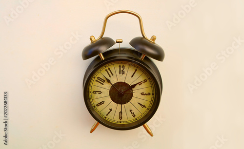 classic retro vintage aged black twin bell alarm clock with the hands pointing to 14 two 2 o'clock, isolated on clean white background symbolizing time deadlines Empty copy space for inscription