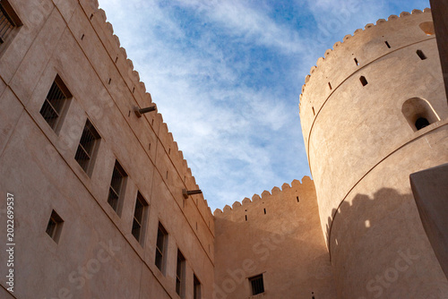 Bild auf Leinwand Majestic Arabic Fortress Architecture Against a Wispy Blue Sky