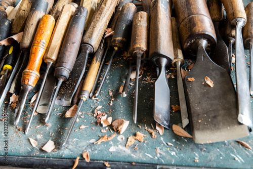 Foto Professional wood carving tools gouges and wooden mallet on an artisan workbench