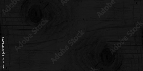 Fotografie Black charred wood texture background with natural organic grain and knots, dark