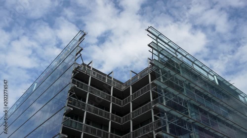 Timelapse footage showing fast-moving clouds passing over Sanomaa House in Helsinki, Finland. The cinematic sky motion highlights changing light and weather over the modern city.