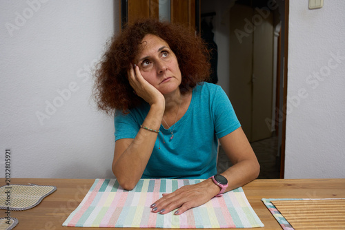 Bored woman sitting at dining table